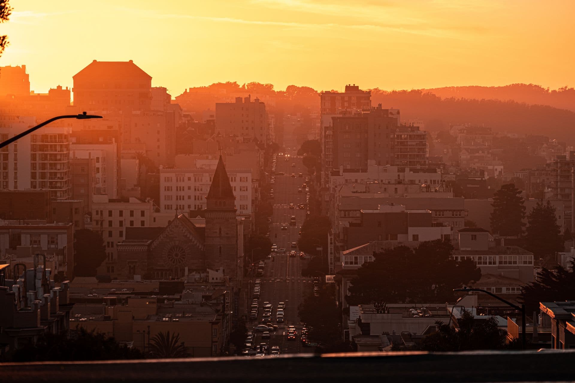 A city skyline of low commercial buildings at dusk.