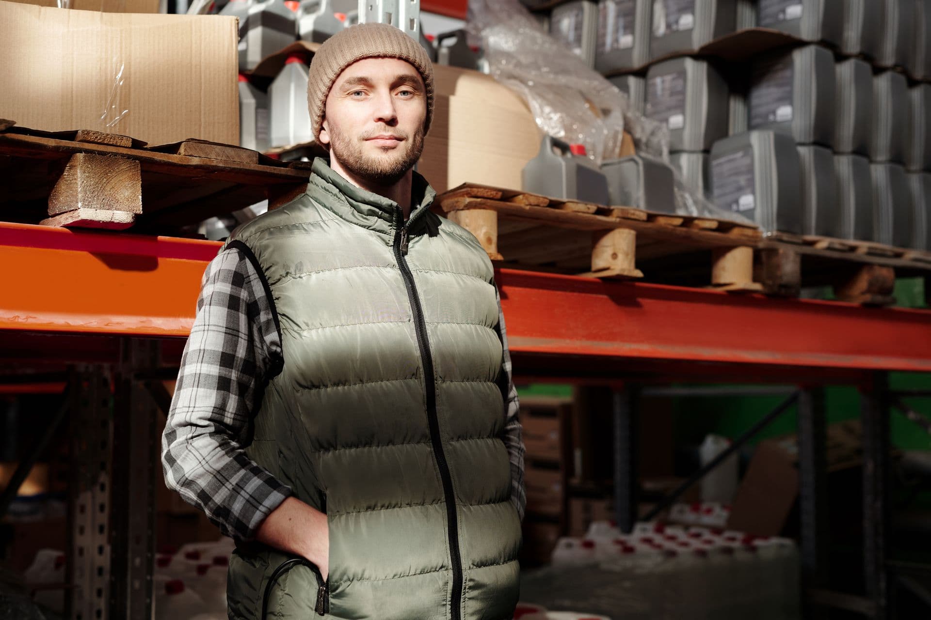 A worker checking stock between the racking of a warehouse.